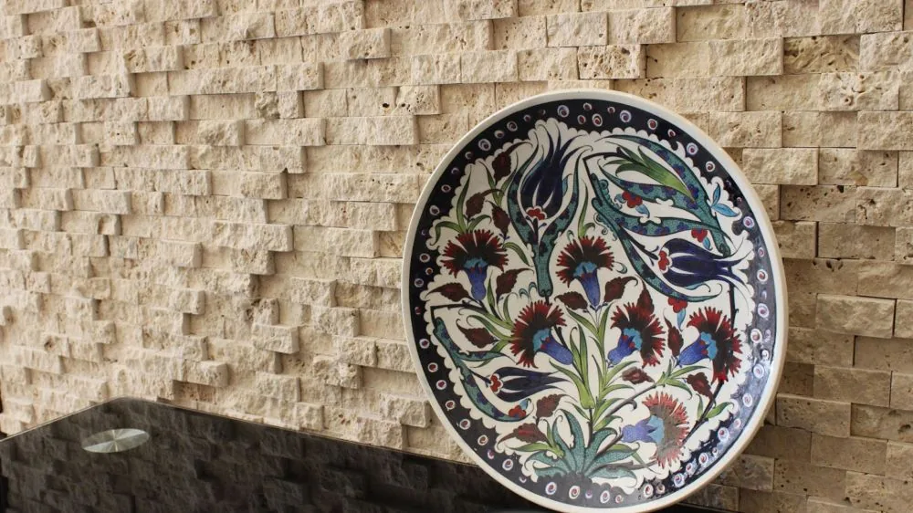 Split face travertine wall with an İznik plate